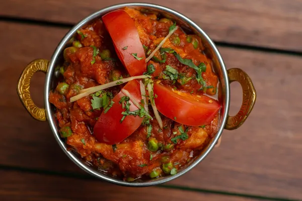 A rich tomato-based karahi finished with herbs and sliced green chilli.