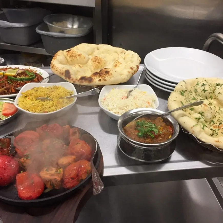 A spread of freshly prepared curries, rice and naan at Spice Room