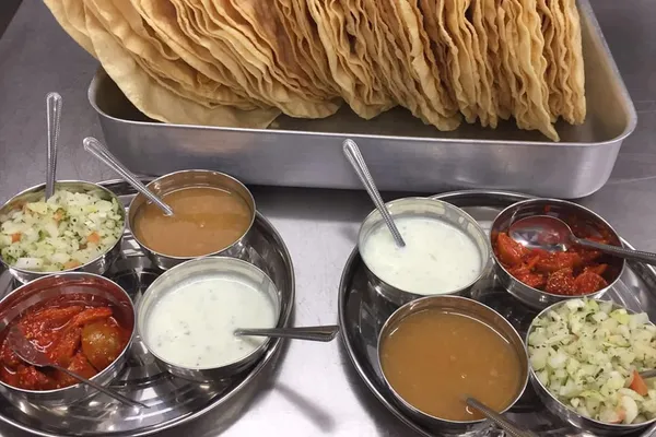 Crisp poppadoms served with chutneys and fresh salad before a meal.